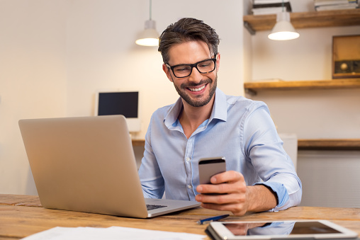 Man working with laptop and smartphone