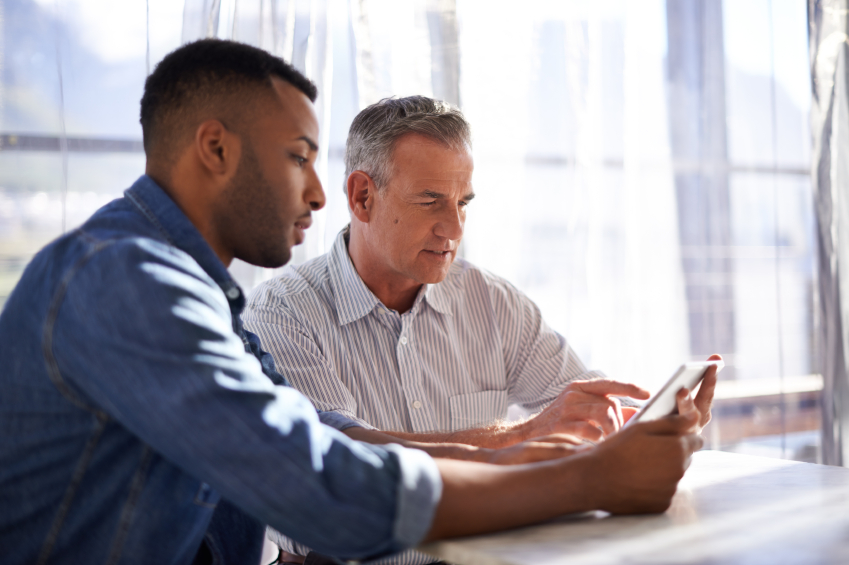 Younger and older man look at papers