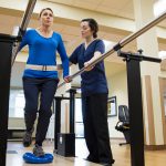 Physical therapist assistant helping a patient