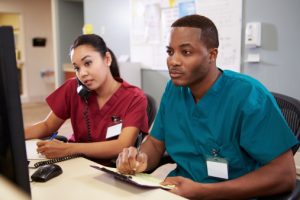 Male and female nurses at desk