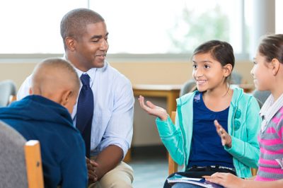 School counselor meeting with elementary age students