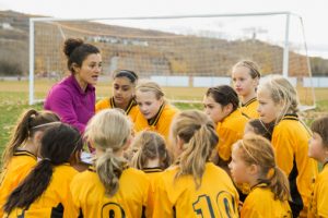 Female coach with girls soccer team