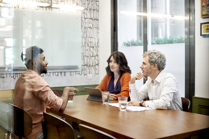 Younger black man interviewing with 2 HR professionals