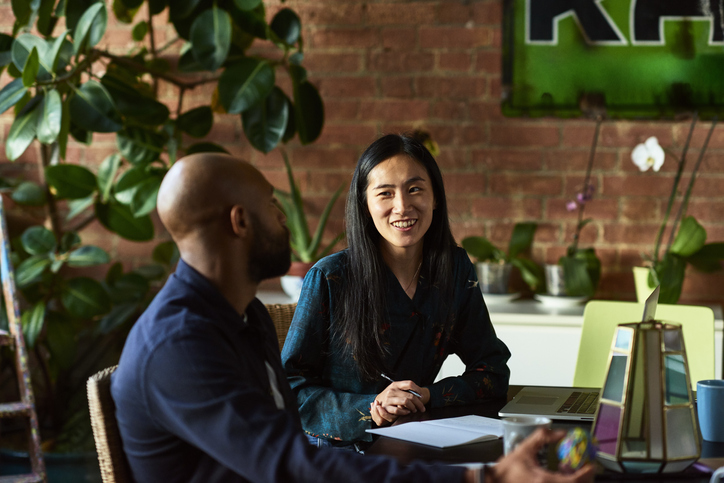 Two people of diverse backgrounds working together