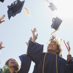 Graduates tossing caps into the air