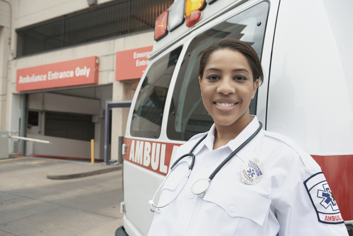 African female EMT next to ambulance